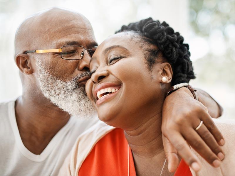 man kissing woman on cheek