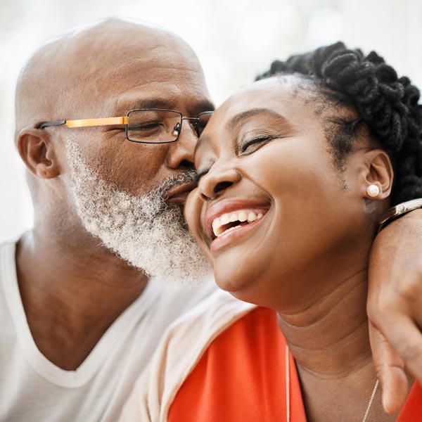 man kissing woman on cheek