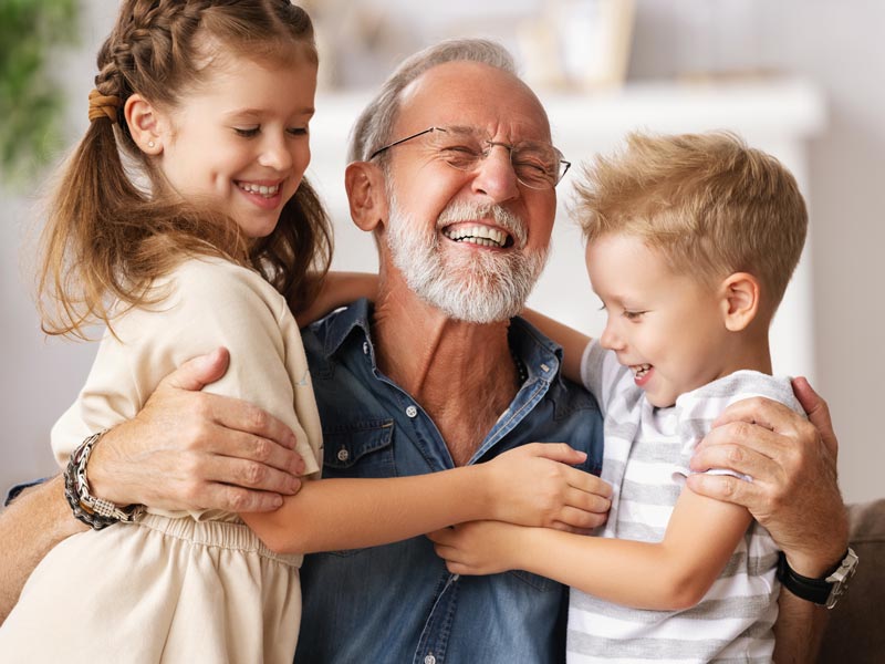 laughing senior man with two grandkids