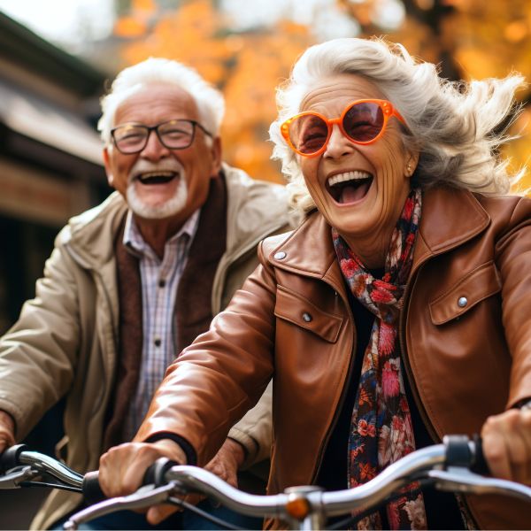 older couple smiling riding bikes